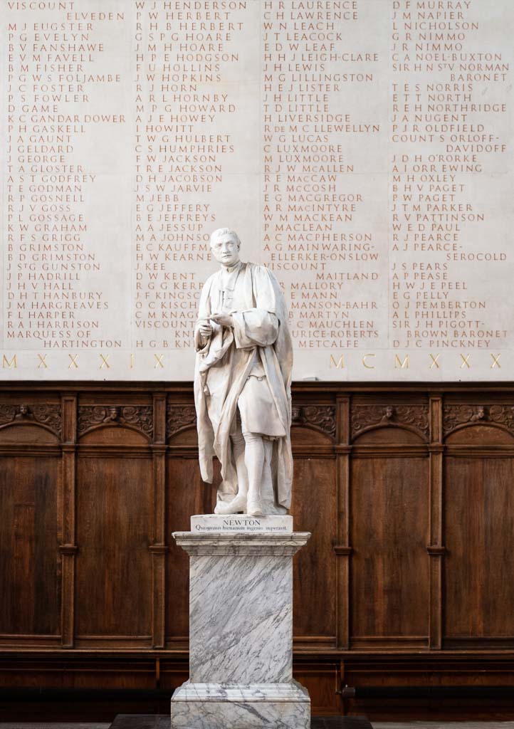The statue of Isaac Newton in the Antechapel at Trinity College, Cambridge in front of part of the memorial to members of the College who died in WW2.